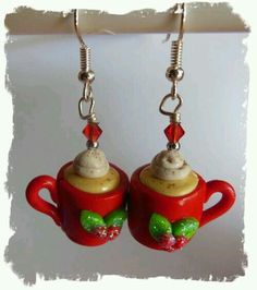 pair of red mugs with cream and candy on them are hanging from silver earwires