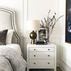 a bedroom with a bed, nightstand and painting on the wall