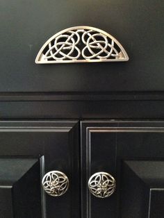 an ornate door handle on a black cabinet