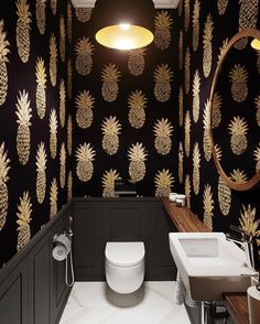 a bathroom with black walls and gold pineapple wallpaper