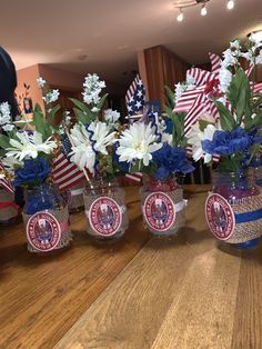 several patriotic vases with flowers in them on a table