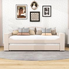 a living room with white couches and pictures on the wall above them, along with a rug