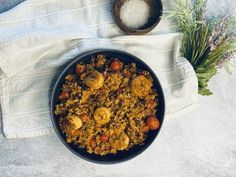 a bowl filled with rice and shrimp on top of a table