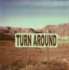 there is a sign that says turn around in the middle of an empty desert area