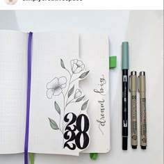 an open notebook with flowers and numbers on it next to markers, pencils and marker pens