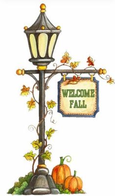 a lamp post with a welcome sign hanging from it's side next to pumpkins