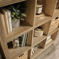 an open book shelf with books and plants