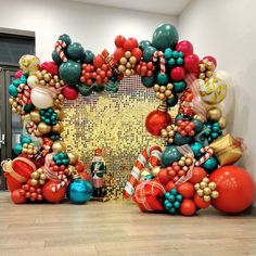 a large balloon arch is decorated with christmas decorations and balloons in the shape of a heart