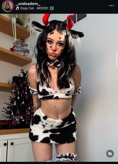 a woman dressed up as a cowgirl posing for the camera with horns on her head