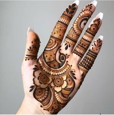 a hand with henna on it and an arrow painted on the top of it