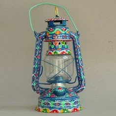 an old fashioned lantern with a colorful design on it