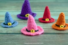 crocheted witches hats sitting on top of a wooden table