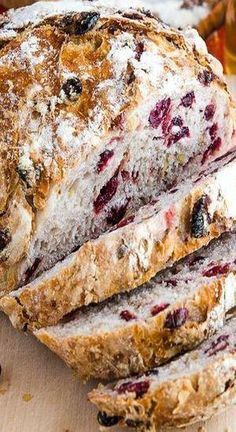 sliced loaf of bread with cranberry toppings on a cutting board