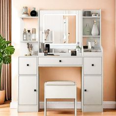 a white vanity with mirror and stool next to a potted plant in a room