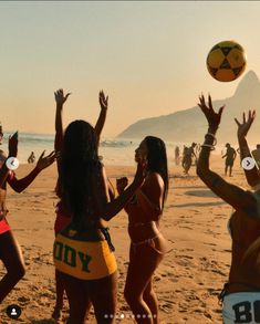 several women on the beach playing with a ball