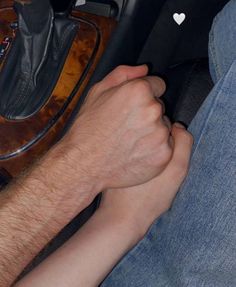 a man sitting in the back seat of a car with his foot on a steering wheel