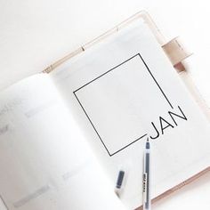 an open book with the word jan written on it next to a marker and pen