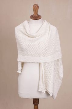 Peruvian artisan Cristina Villalobos designs a warm white shawl that combines the luxurious softness and warmth of alpaca with the resilience of acrylic and wool fibers. Knit in an eyelet pattern interspersed with three bands of cable pattern the shawl has a lovely relaxed drape and is wide enough to be worn either as a wrap or across the shoulders like a cape. Traditional White Scarves For Winter, Traditional White Winter Scarves, White Bohemian Winter Shawl, Bohemian Cream Knitted Shawl, Elegant Hand Knitted Alpaca Shawl, Hand Knitted Alpaca Shawl, Cream Hand Knitted Shawl For Winter, Winter Cream Hand Knitted Shawl, Knitted Alpaca Shawl