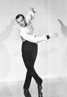 a man in white shirt and black pants dancing