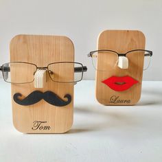 two wooden frames with glasses and mustaches on them, one is made to look like a man's face