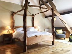 a large bed sitting inside of a bedroom on top of a hard wood floor