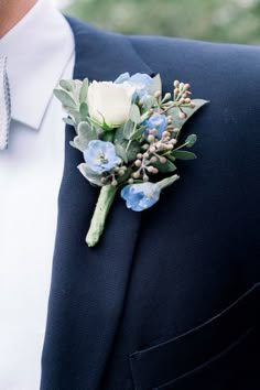 a man wearing a suit and tie with a boutonniere on his lapel