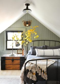 a bedroom with a bed, nightstands and flowers in the vase on the table