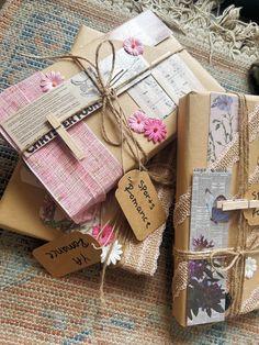 three wrapped presents with tags and twine tied to them sitting on a carpeted area