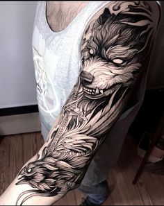 a man's arm with a wolf and feathers tattoo on the left side of his arm