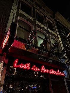 the front of a restaurant with christmas lights on it's windows and decorations hanging from the building