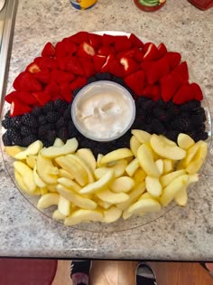 fruit arranged in the shape of a circle on a counter top with dip and yogurt