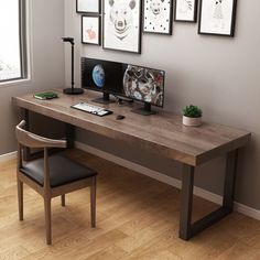 a desk with a computer, chair and pictures on the wall