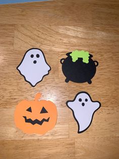 four halloween cut outs sitting on top of a wooden floor