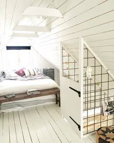 an attic bedroom with white walls and wood floors