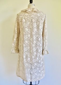 "The 1960's saw a revolution in what women chose to wear. No longer was there a need for girdles to cinch the waist but rather a \"Youth Quake\" (think Mary Quant) took place that saw the introduction of mini skirts and A line silhouettes. This fantastic 60's dress is made in a creme/ivory cotton lace that is finely crocheted (by machine). Highest quality construction. A-line silhouette with a ruffle at the round neckline and at the center front opening that is made up of a layer of lace and a l Classic Spring Dresses For Church, Beige Fitted Victorian Dress, Vintage Fitted Dresses For Church, Victorian Beige Dress With Ruffles, Classic Cream Dress For Vintage Events, Cream Wedding Dress With Lace Cuffs, Vintage White Ruffled Dress, Vintage White Dress With Ruffles, Classic Vintage White Dress For Vintage Events