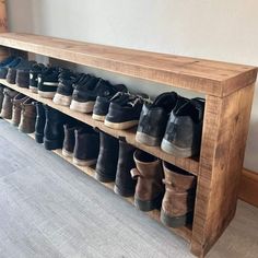 a wooden shoe rack with several pairs of shoes on it and two rows of them