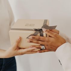 a person holding a box with a ring on it