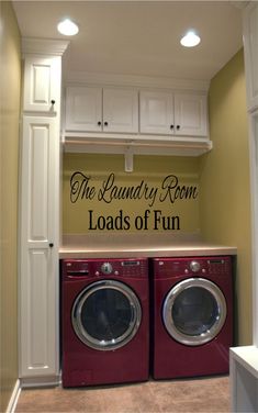 a washer and dryer in a laundry room with cabinets above them, next to each other