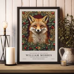 a painting of a red fox surrounded by holly and berries on a shelf next to a candle