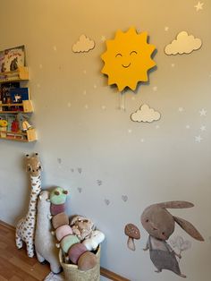 there are stuffed animals on the floor in this child's room with wall decals