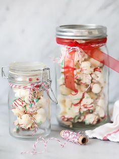 two glass jars filled with candy canes and marshmallows