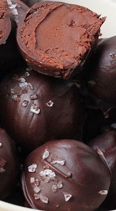 a white bowl filled with chocolate truffles covered in sea salt