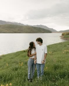 a man and woman standing next to each other in the grass