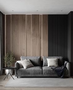 a modern living room with wood paneling on the wall and grey couch in front