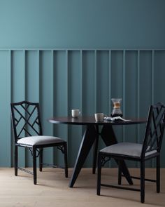 two chairs and a table in front of a blue wall