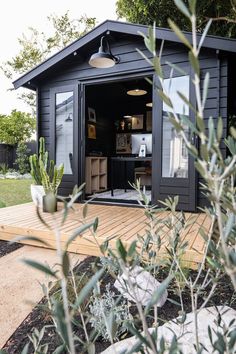 a small black shed sitting on top of a wooden deck