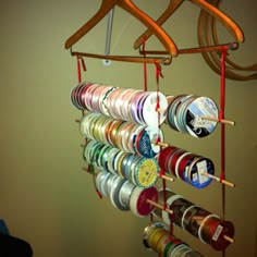 a rack with many different types of thread spools hanging from it