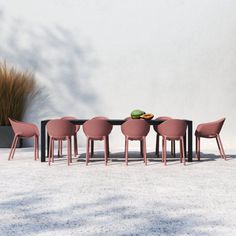 a group of pink chairs sitting around a table