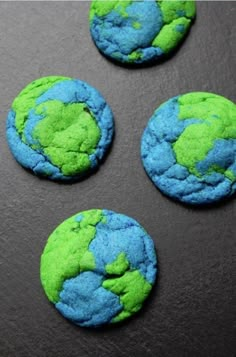 four green and blue cookies with the earth on them