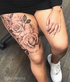 a woman's thigh with roses on it and her hand resting on the leg